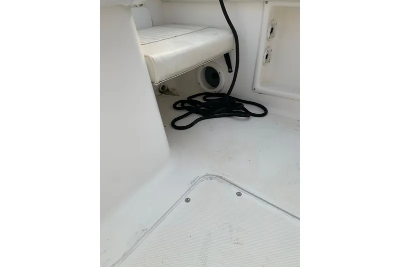 Slide: The Image of Interior of a 2006 Sea Hunt Triton 220 boat, featuring seating and coiled rope. - 28
