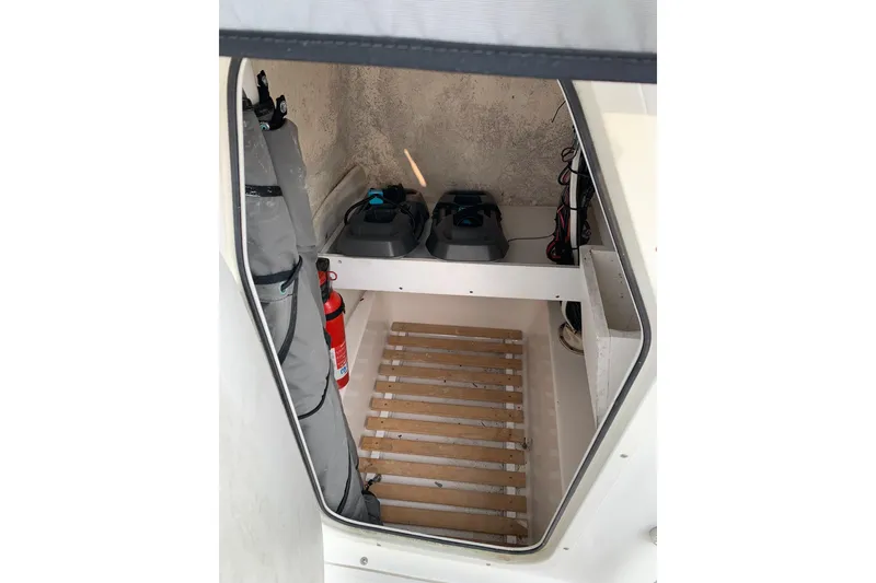 Slide: The Image of Interior view of a 2006 Sea Hunt Triton 220 boat storage compartment with equipment and fire extinguisher. - 29
