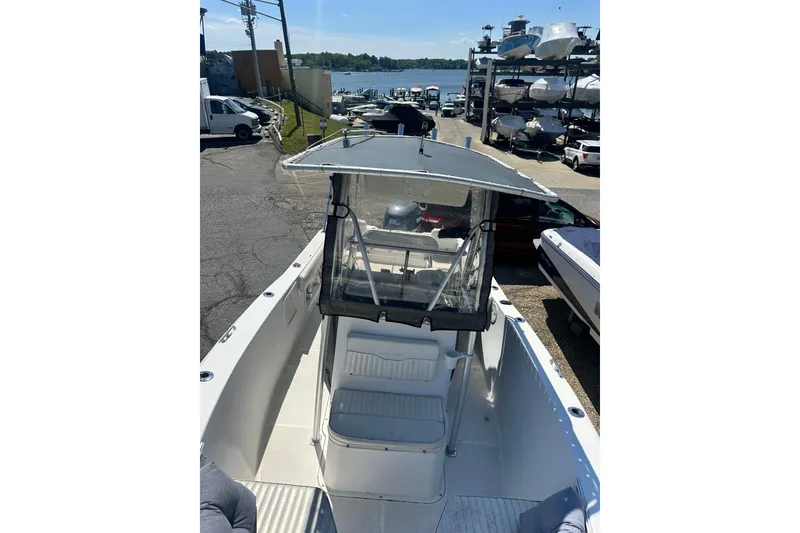 Slide: The Image of 2006 Sea Hunt Triton 220 boat docked, featuring a covered console and seating area. - 39
