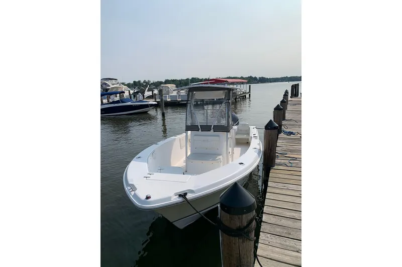 Slide: The Image of 2006 Sea Hunt Triton 220 boat docked at a marina on a sunny day. - 4