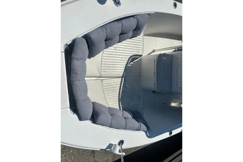 Slide: The Image of 2006 Sea Hunt Triton 220 boat interior with cushioned seating and white deck. - 42