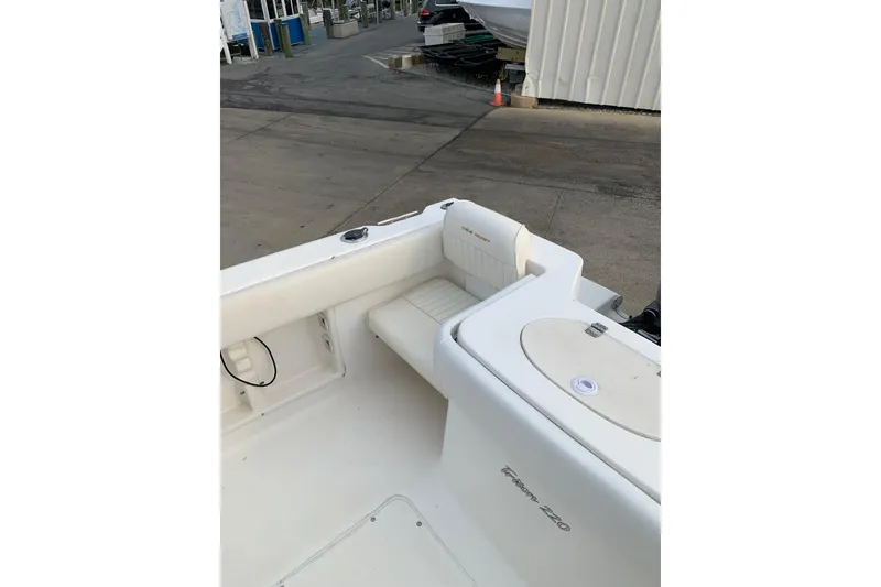 Slide: The Image of 2006 Sea Hunt Triton 220 boat interior, featuring white seating and storage compartments. - 8