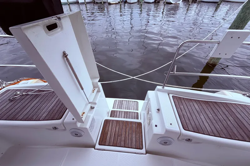 Slide: The Image of Beneteau Oceanis 40 yacht stern view, featuring teak decking and open hatch, docked at marina. - 17
