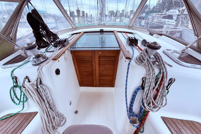 Slide: The Image of 2009 Beneteau Oceanis 40 sailboat cockpit with dual steering wheels and wooden table, docked at marina. - 35