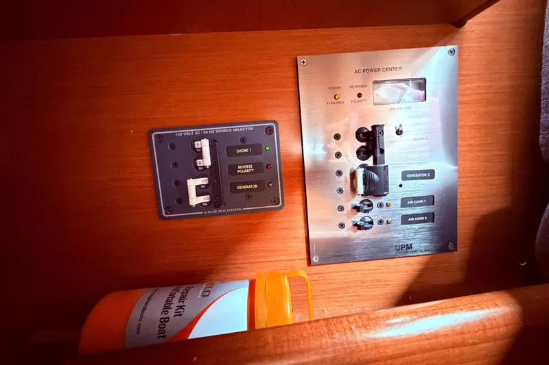 Slide: The Image of Electrical panel on a 2009 Beneteau Oceanis 40 sailboat, featuring power controls and repair kit. - 85