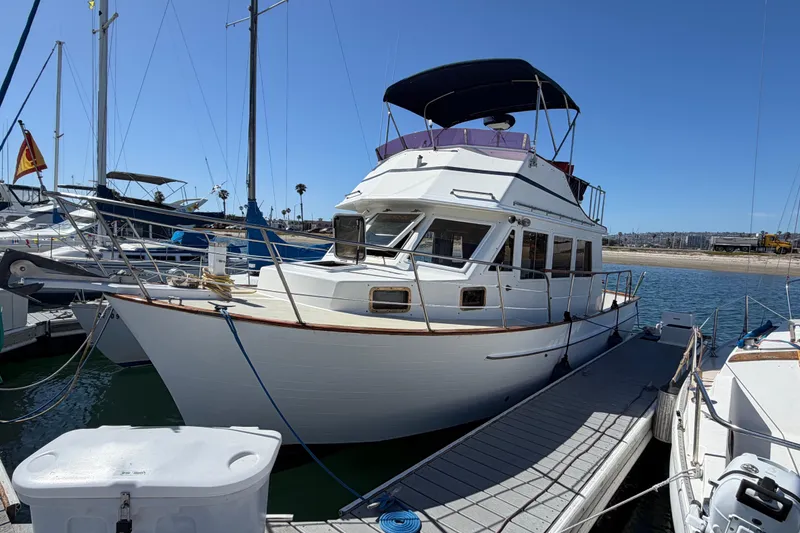 The Image of 1982 Lien Hwa 31 yacht docked at marina under clear blue sky. - 1