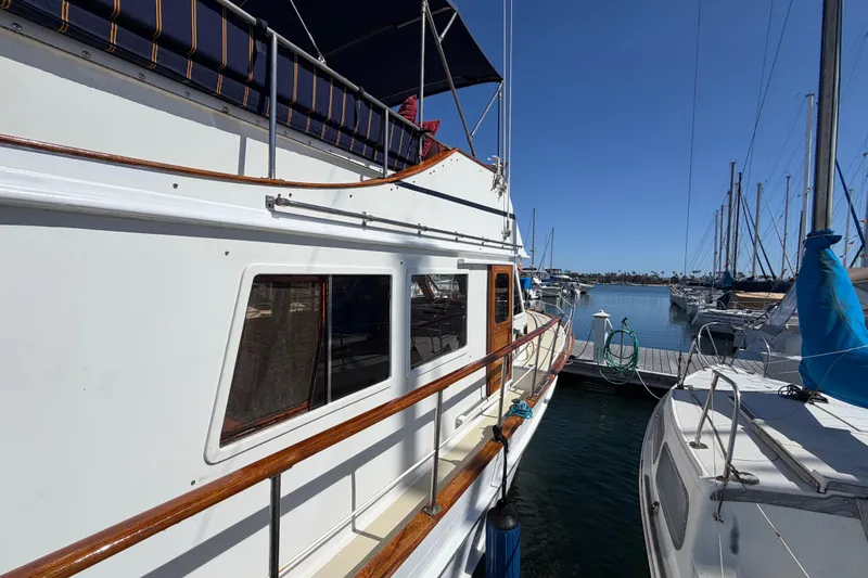 Slide: The Image of 1982 Lien Hwa 31 yacht docked at marina, featuring wooden railings and blue canopy. - 11