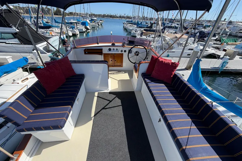 Slide: The Image of 1982 Lien Hwa 31 yacht interior with striped seating, docked at a marina. - 15
