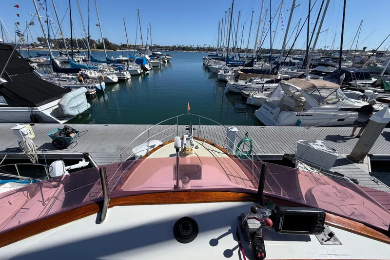 Slide: The Image of 1982 Lien Hwa 31 yacht docked at a marina, surrounded by sailboats under a clear blue sky. - 23