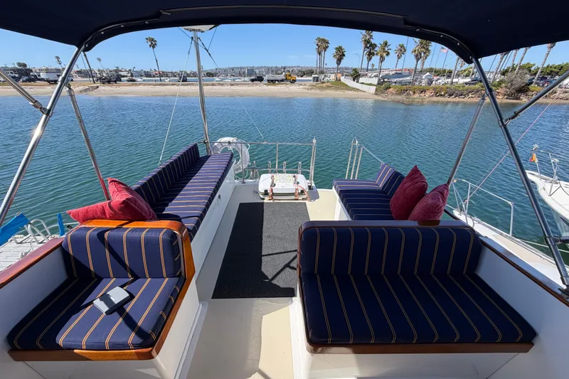 Slide: The Image of 1982 Lien Hwa 31 yacht interior with striped seating, overlooking a scenic waterfront. - 24
