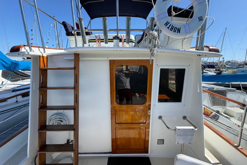 Slide: The Image of 1982 Lien Hwa 31 yacht with wooden door, ladder, and lifebuoy in a marina setting. - 25