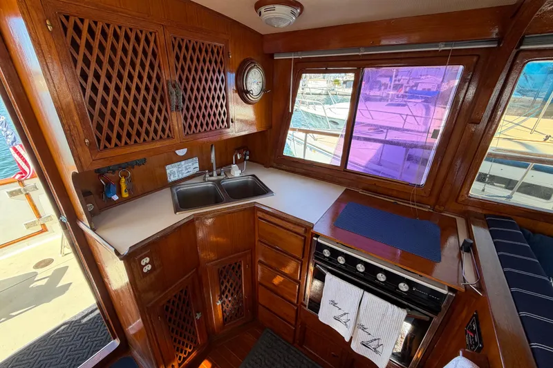 Slide: The Image of 1982 Lien Hwa 31 yacht interior kitchen with wooden cabinetry and dual sinks. - 31