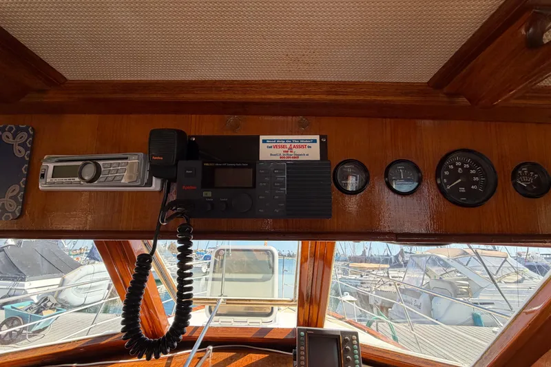 Slide: The Image of 1982 Lien Hwa 31 boat dashboard with radio and gauges, docked at marina. - 38