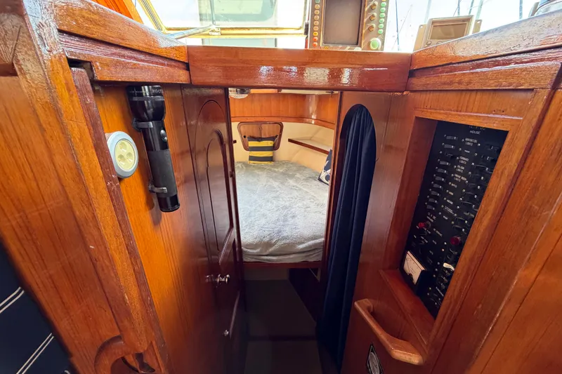 Slide: The Image of 1982 Lien Hwa 31 boat interior with wood paneling, cozy sleeping area, and control panel. - 43