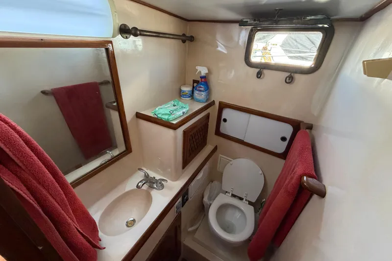 Slide: The Image of Compact 1982 Lien Hwa 31 boat bathroom with sink, toilet, and red towels. - 49