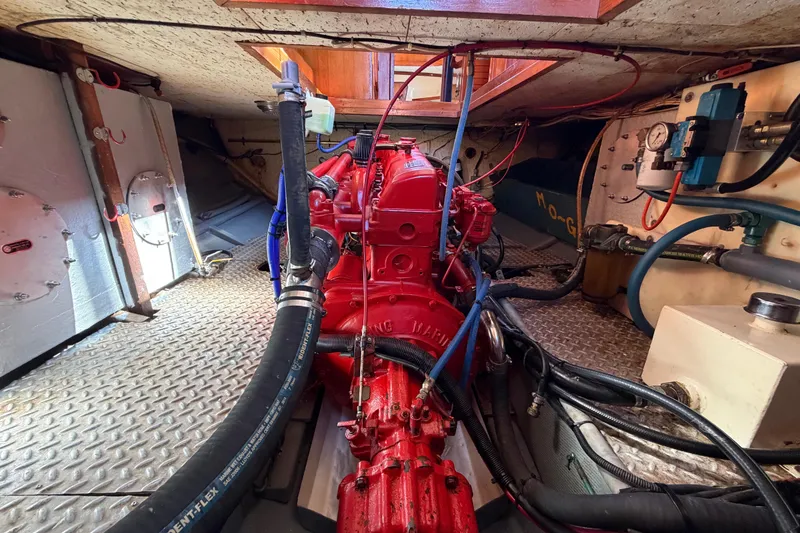 Slide: The Image of Engine room of 1982 Lien Hwa 31 boat, featuring a red marine engine and various hoses. - 53