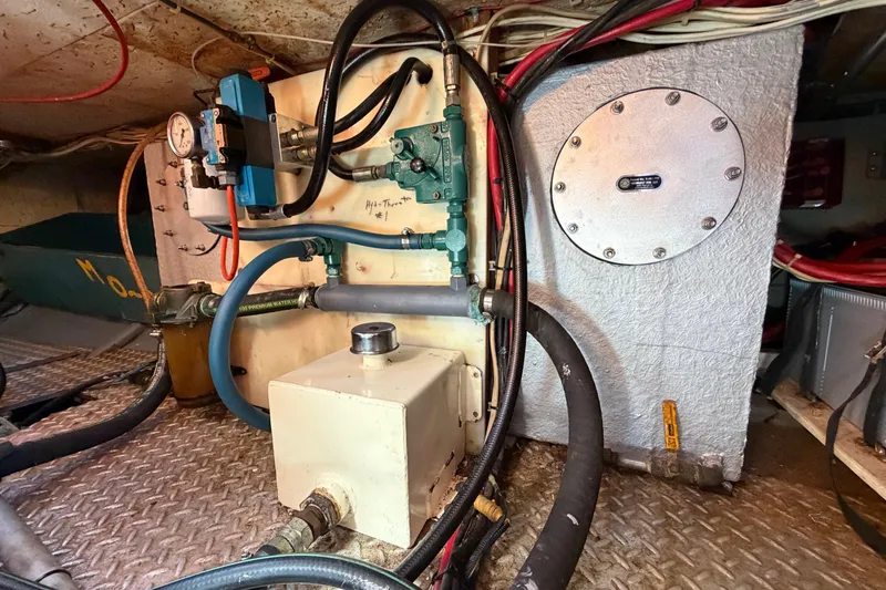 Slide: The Image of Engine room of a 1982 Lien Hwa 31 boat, featuring hydraulic components and wiring. - 55