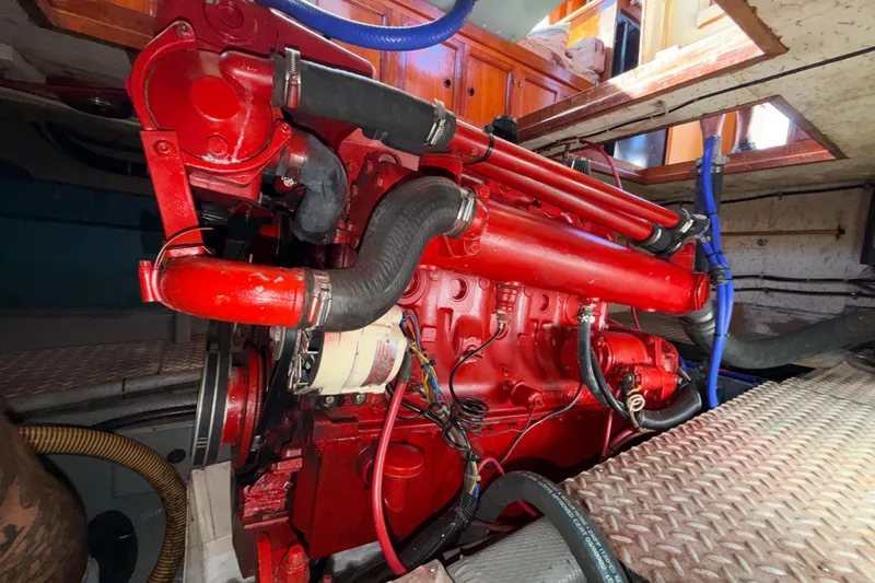 Slide: The Image of Red engine inside a 1982 Lien Hwa 31 boat, showcasing mechanical components and hoses. - 64