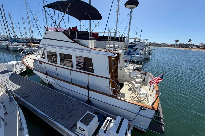 Slide: The Image of 1982 Lien Hwa 31 yacht docked in marina, featuring spacious deck and American flag. - 7