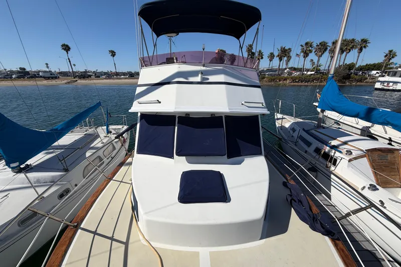 Slide: The Image of 1982 Lien Hwa 31 yacht docked, surrounded by sailboats, with clear blue skies and palm trees. - 71