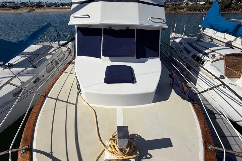 Slide: The Image of 1982 Lien Hwa 31 yacht deck with blue cushions, docked between boats. - 72