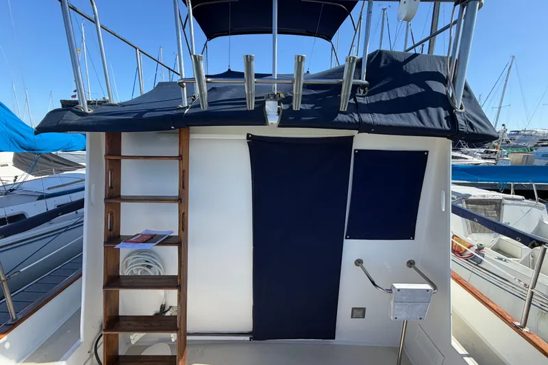 Slide: The Image of 1982 Lien Hwa 31 boat with wooden ladder and blue canopy in marina setting. - 77