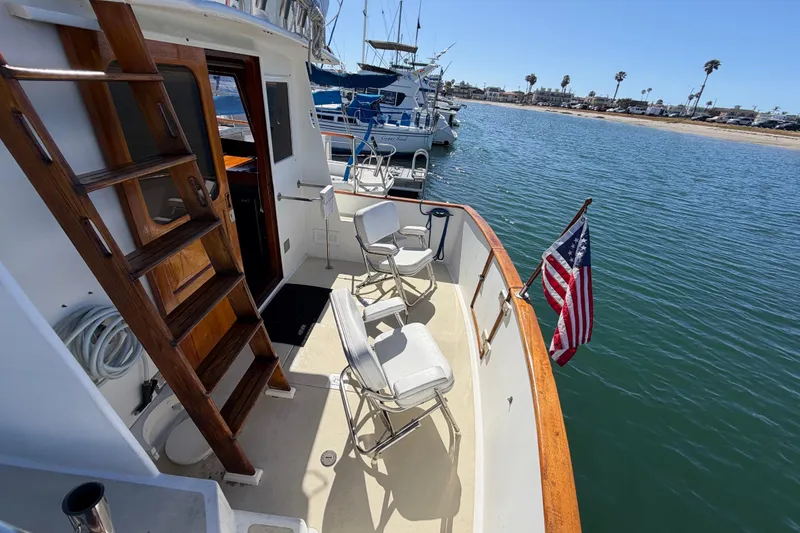 Slide: The Image of 1982 Lien Hwa 31 boat deck with chairs and American flag, docked by the shore. - 9