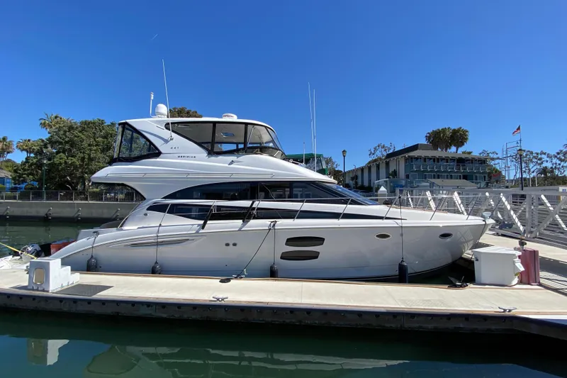 Slide: The Image of 2011 Meridian 441 Sedan yacht docked at marina under clear blue sky. - 2