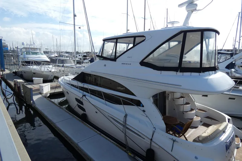 Slide: The Image of 2011 Meridian 441 Sedan yacht docked at marina, showcasing sleek design and spacious upper deck. - 4
