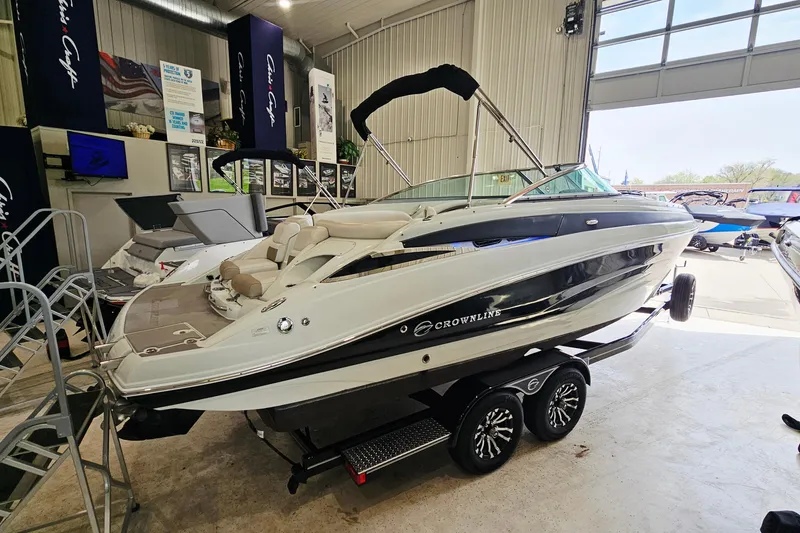 The Image of 2014 Crownline 255 SS boat on trailer in showroom setting. - 1