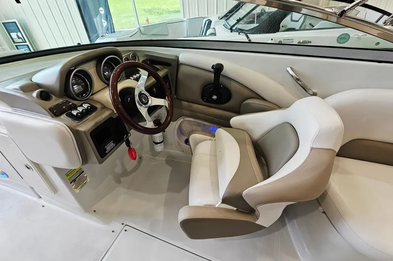 Slide: The Image of Interior view of 2014 Crownline 255 SS boat cockpit with steering wheel and controls. - 12