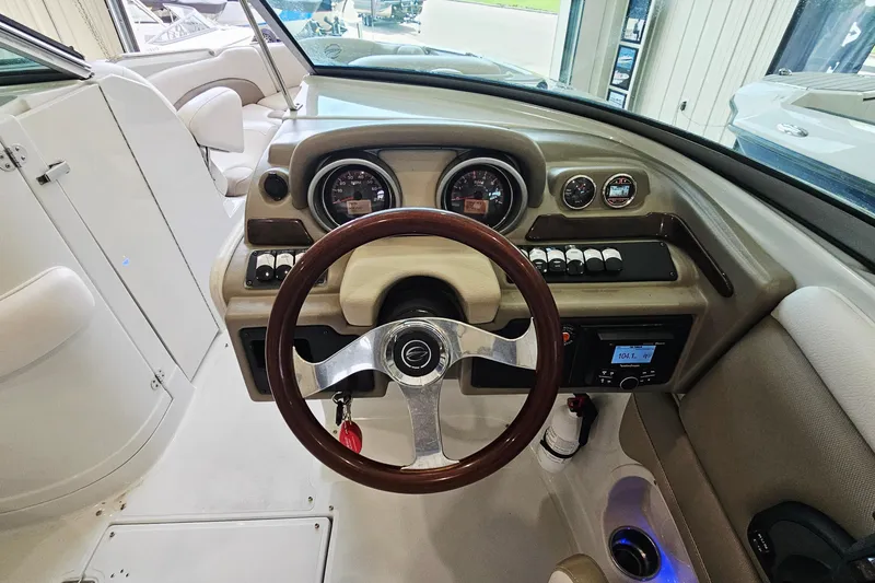 Slide: The Image of 2014 Crownline 255 SS boat dashboard with steering wheel and control gauges. - 13