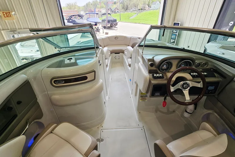 Slide: The Image of 2014 Crownline 255 SS boat interior with steering wheel and seating, showcasing dashboard controls. - 14