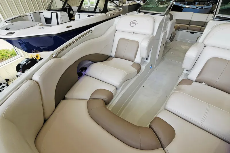Slide: The Image of 2014 Crownline 255 SS boat interior with beige and brown seating in a showroom. - 18