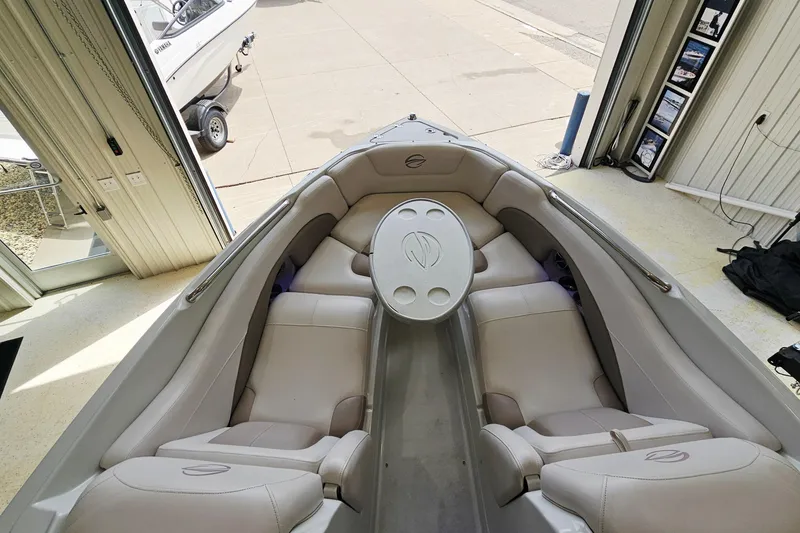 Slide: The Image of 2014 Crownline 255 SS boat interior with beige seating and round table in showroom. - 21
