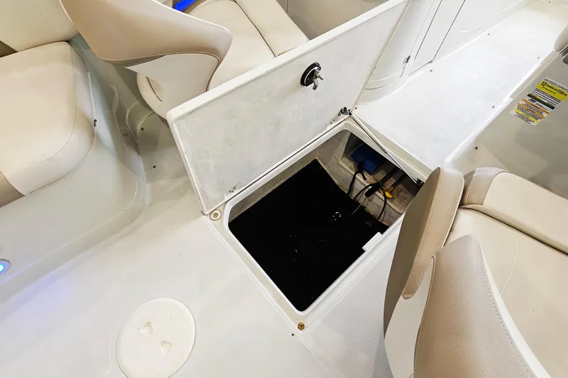 Slide: The Image of 2014 Crownline 255 SS boat interior with open storage compartment and beige seating. - 23