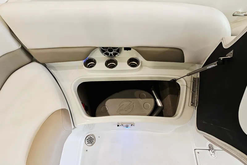 Slide: The Image of 2014 Crownline 255 SS boat interior storage compartment with cup holders and speaker. - 24