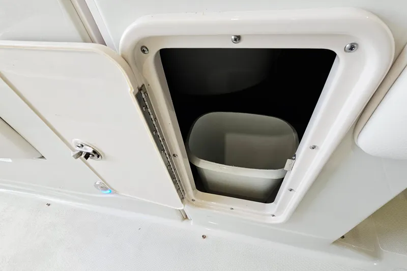 Slide: The Image of Storage compartment with trash bin on 2014 Crownline 255 SS boat. - 26