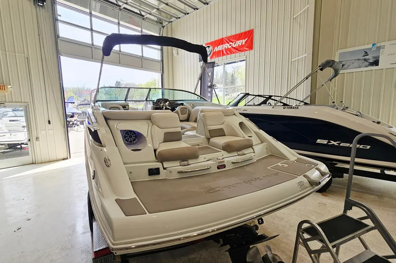 Slide: The Image of 2014 Crownline 255 SS boat displayed in a showroom with open garage door. - 4