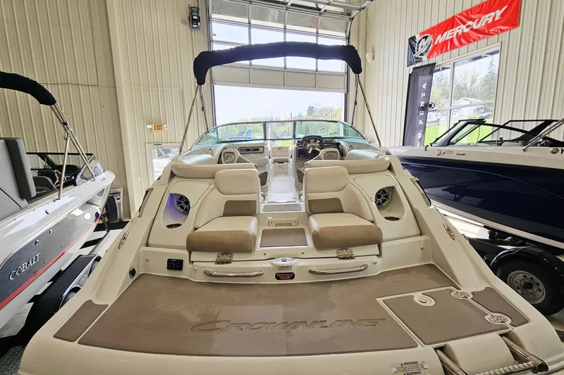 Slide: The Image of 2014 Crownline 255 SS boat interior in showroom, featuring seating and control panel. - 5