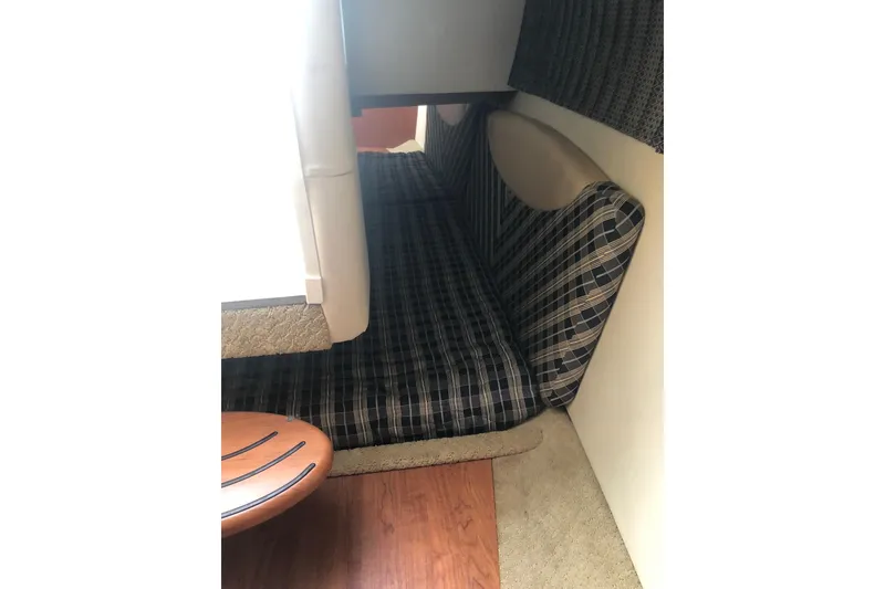 Slide: The Image of Interior cabin of 2009 Formula 350 Sun Sport with plaid seating and wooden table. - 12