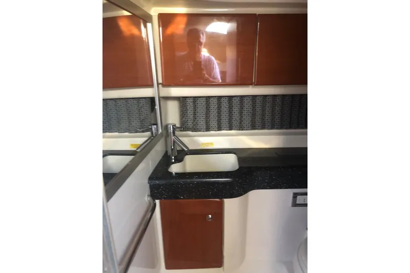 Slide: The Image of 2009 Formula 350 Sun Sport bathroom interior with sink and wooden cabinetry. - 13