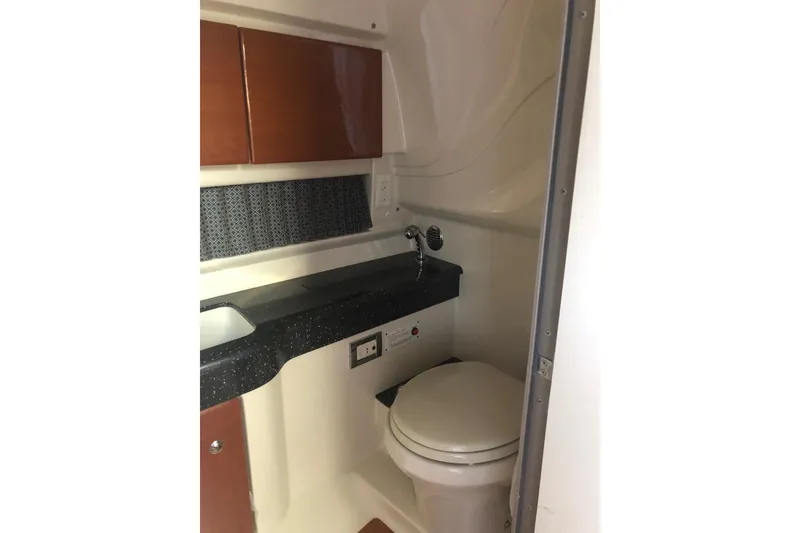 Slide: The Image of 2009 Formula 350 Sun Sport boat bathroom with sink, toilet, and storage cabinets. - 14