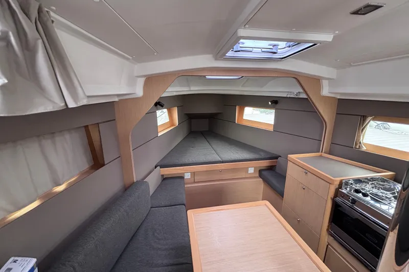 Slide: The Image of Interior of 2015 Beneteau Oceanis 35 sailboat, featuring cozy seating and modern kitchen amenities. - 11