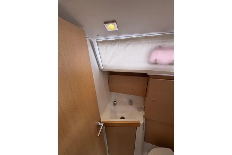 Slide: The Image of Interior of 2015 Beneteau Oceanis 35 bathroom with sink and wooden cabinetry. - 17