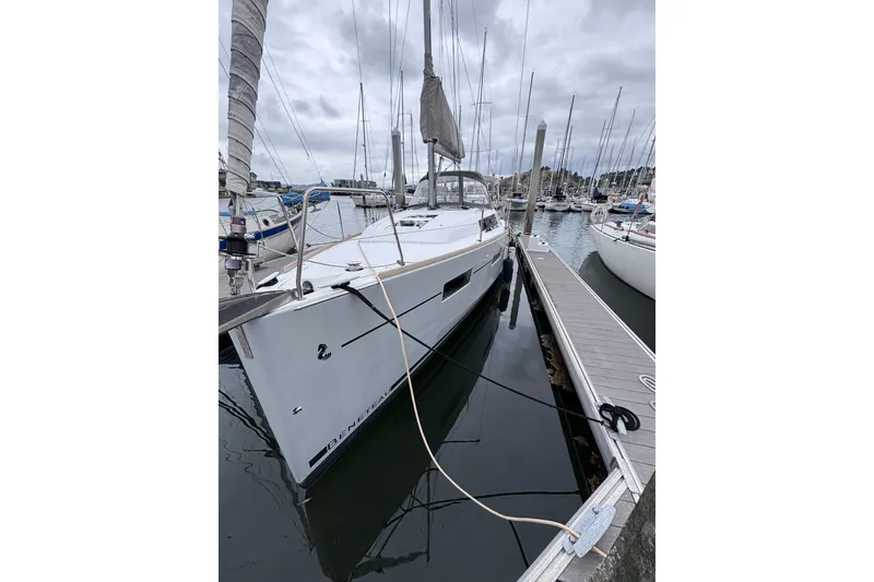 Slide: The Image of 2015 Beneteau Oceanis 35 sailboat docked in a marina under cloudy skies. - 2