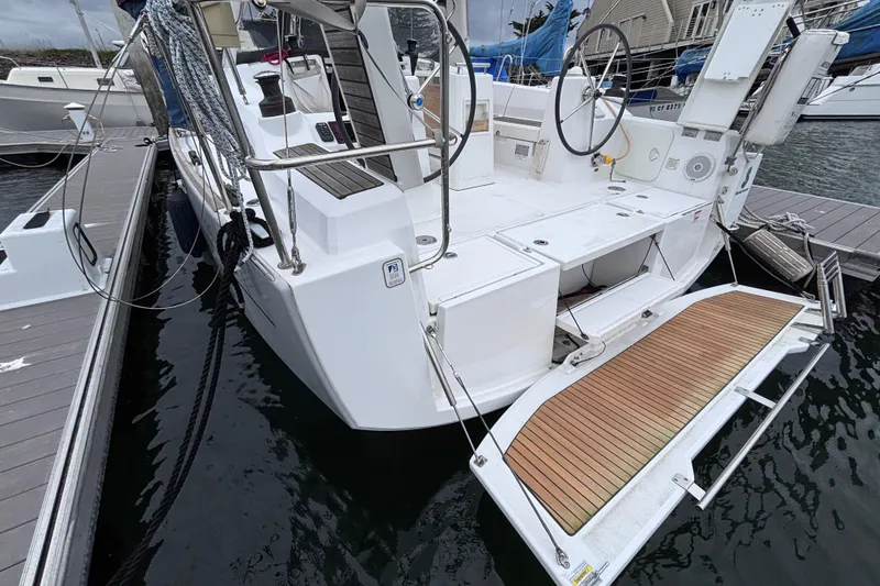 Slide: The Image of 2015 Beneteau Oceanis 35 sailboat docked, featuring a spacious cockpit and swim platform. - 6
