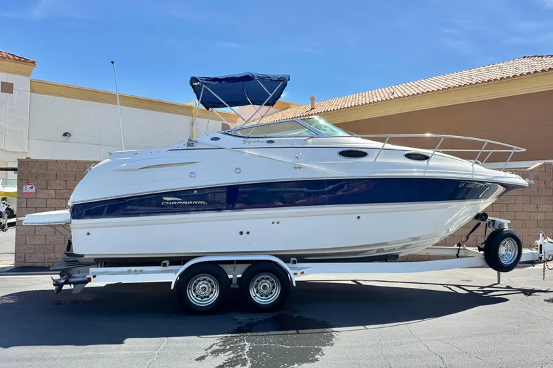 The Image of 2004 Chaparral Signature 260 boat on trailer, parked outdoors under clear sky. - 0