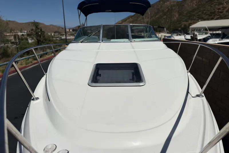 Slide: The Image of 2004 Chaparral Signature 260 boat with sleek white deck and windshield, docked outdoors. - 13