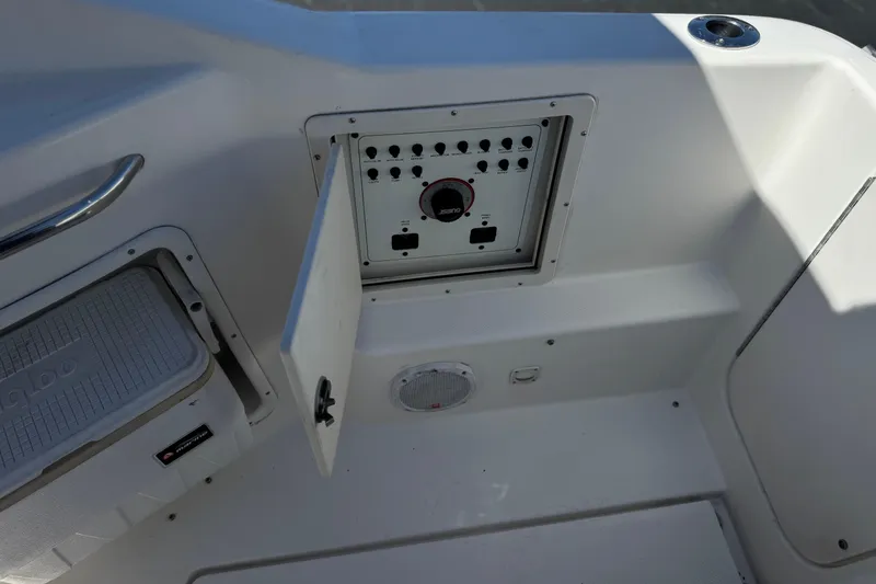 Slide: The Image of 2004 Chaparral Signature 260 boat control panel with open compartment and cooler. - 15